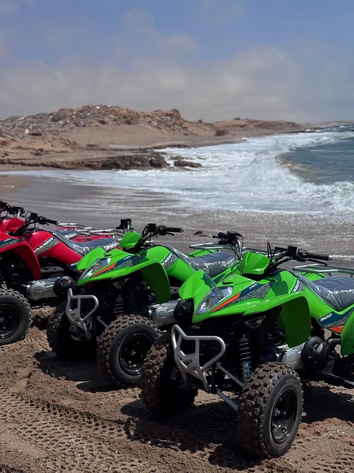 Quads garés sur la plage, là où le sable rencontre les vagues de l'Atlantique.