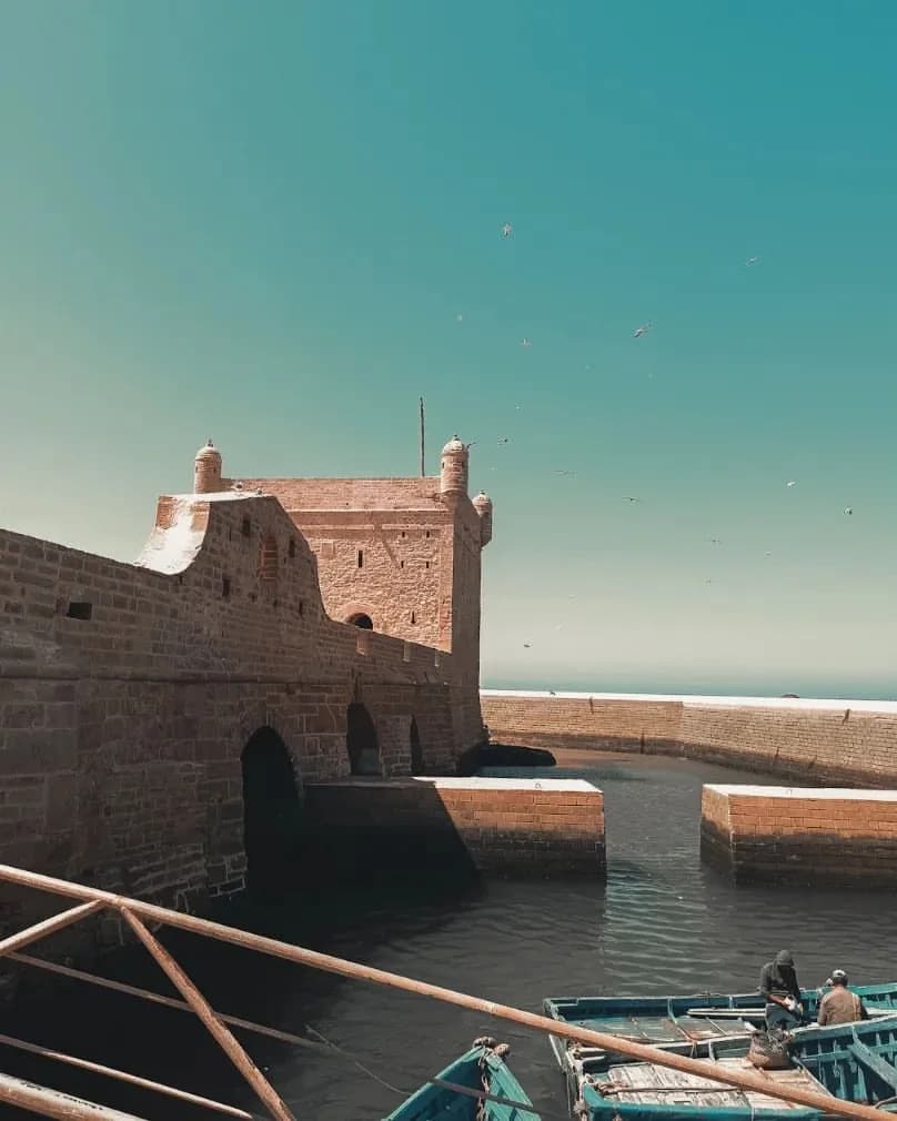 El bastión del puerto de Essaouira sobre las barcas de pesca azules.