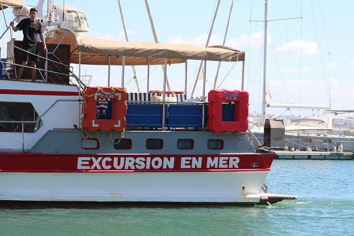 The excursion boat moored in Agadir marina, its hull painted with the words Excursion en mer.